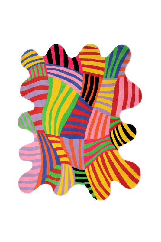 Image of the Squiggle Stripe Rug with an abstract stripe pattern containing yellow, green, red, blue, orange, black, pink, and purple. This rug is hand-tufted in India from a 100% wool fiber with cotton backing. It measures 60” x 76” and is an irregular squiggle shape