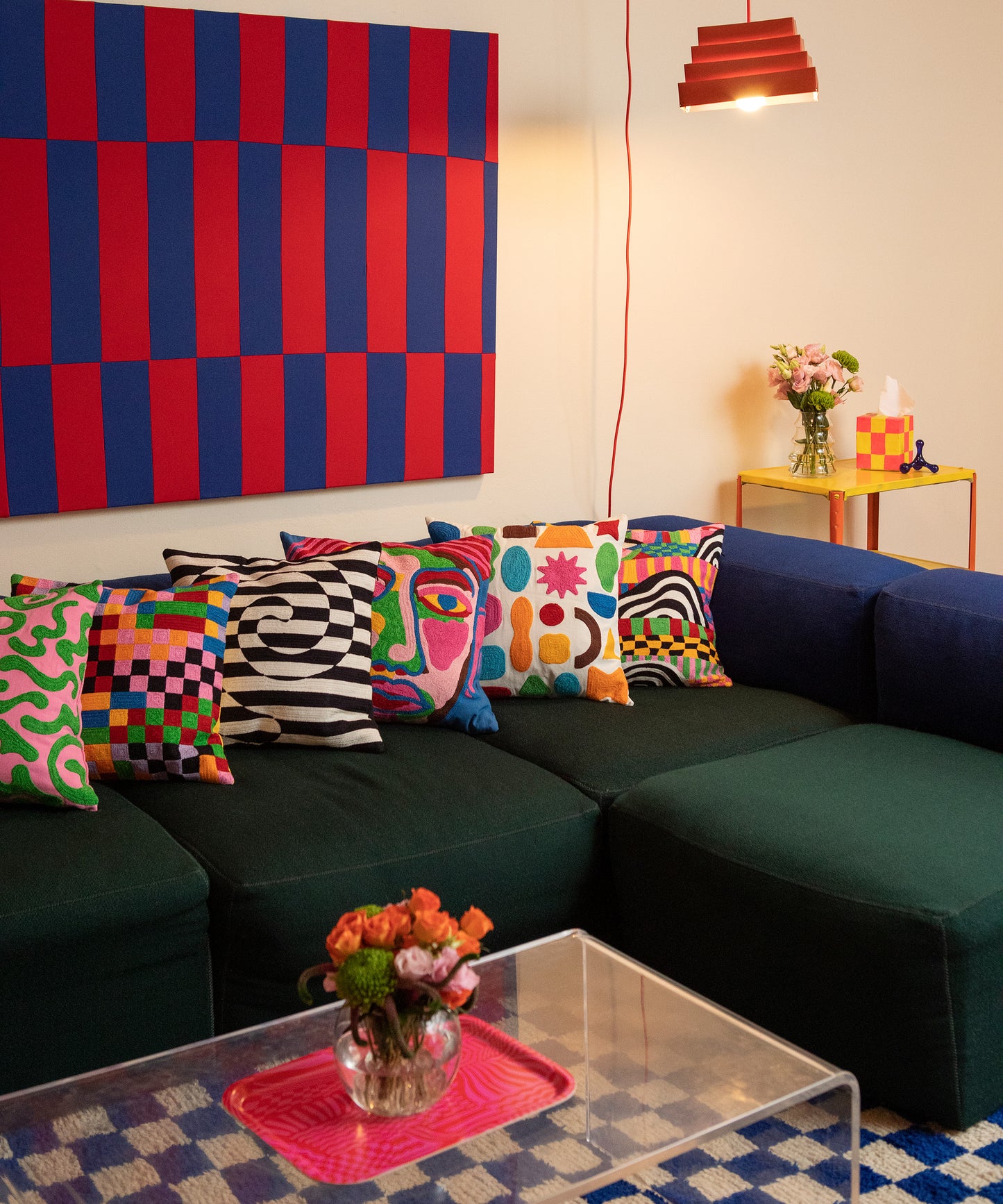 Image of all 6 pillow cover designs laying horizontally on a couch with the Wiggles and Waves Tray sitting on the coffee table with a vase of flowers.