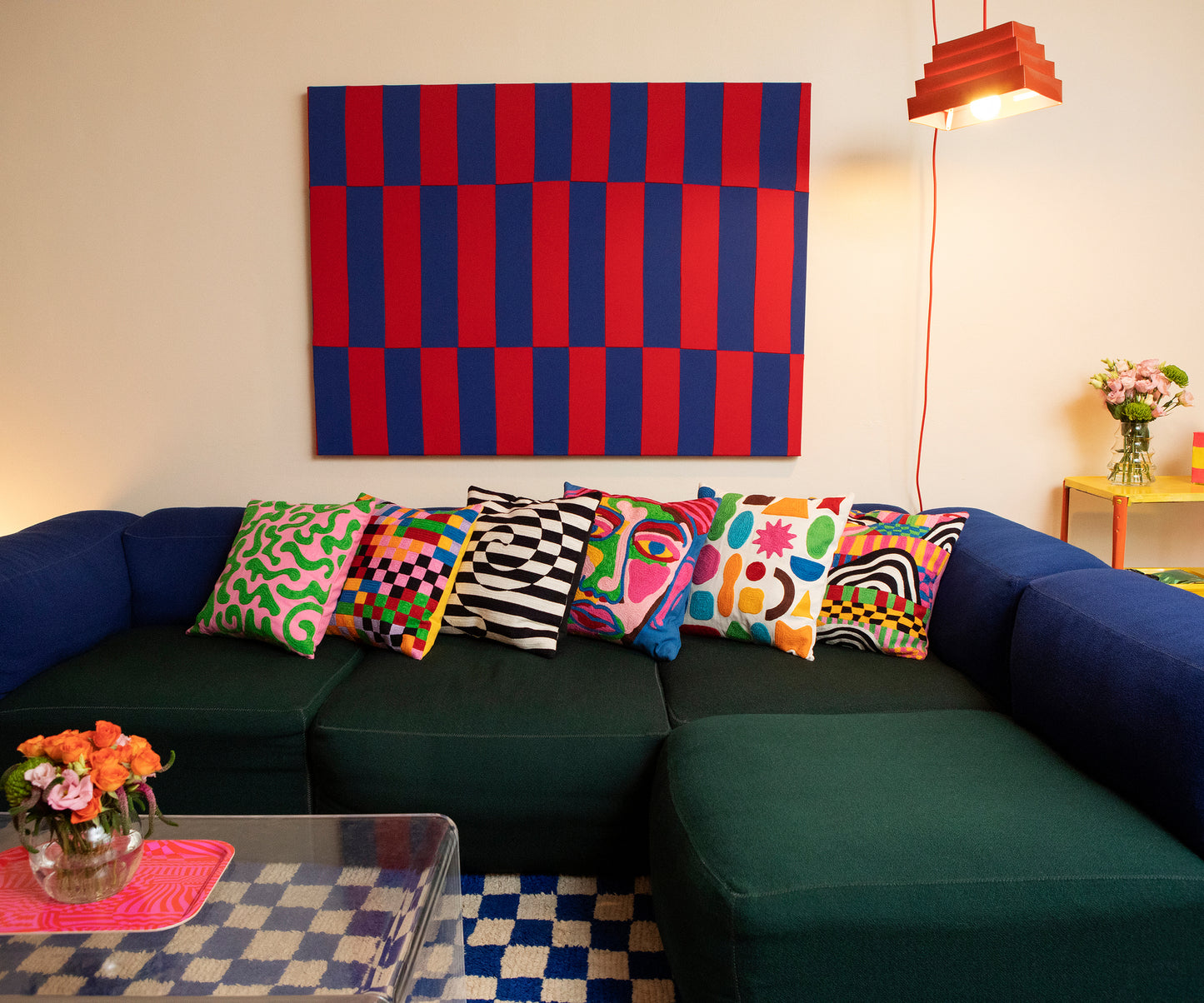 Detail of the Dazzle Pillow Cover along with the five other pillow cover designs placed horizontally along a blue and green couch. 