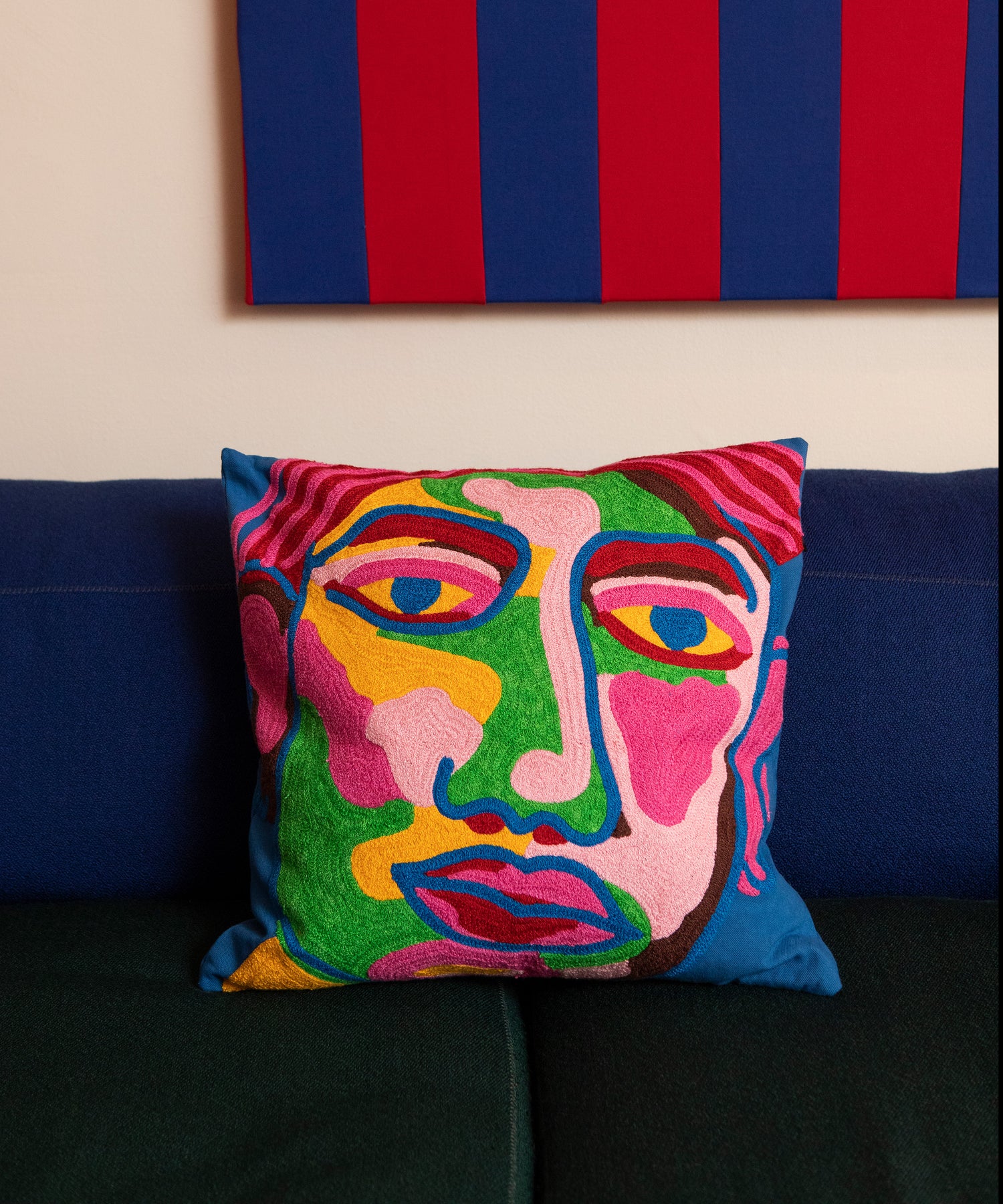 Detail of the Portrait Pillow by itself on a blue and green couch.