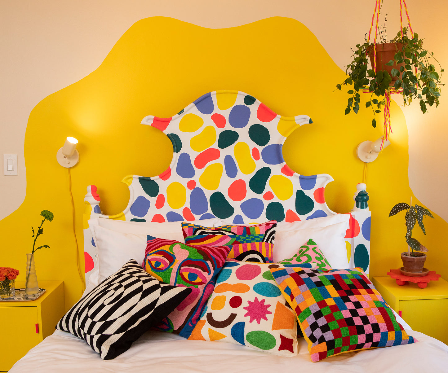 Image of Pixels Pillow piled onto a made bed sitting with the five other pillow designs from the 2022 Fall Collection.
